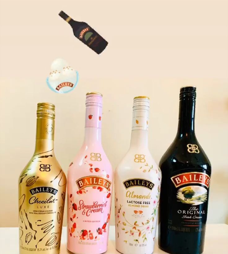 three different types of liquor bottles on a table with an object in the air above them