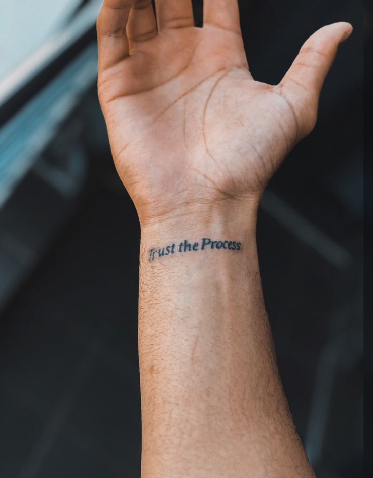 a person's hand with a tattoo saying trust the process