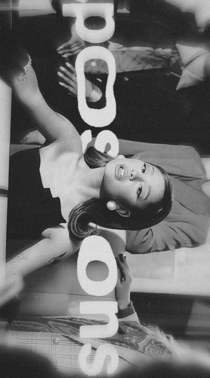 a black and white photo of a woman laying on the ground with her arms up