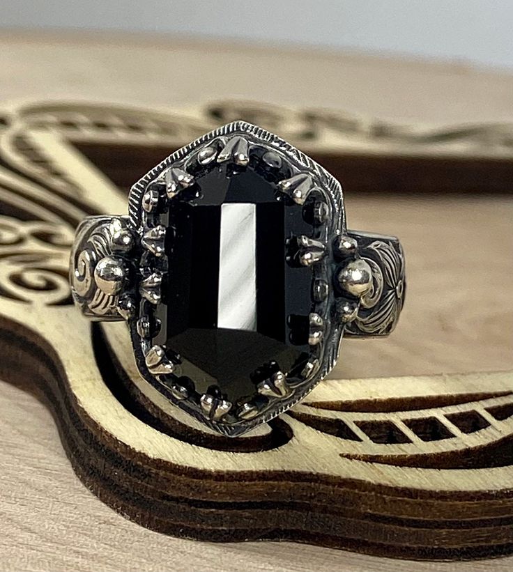 Natural black onyx set in sterling silver with an antiqued finish. I have several more of these beautiful stones in stock for custom orders. The band is 6mm wide, it is best to go up a quarter size larger with wider bands. Custom orders are welcome. Feel free to contact me with questions or comments. Gothic Sterling Silver Jewelry With Polished Finish, Black Jewelry With Custom Hardware As Gift, Gothic Sterling Silver Jewelry, Black Gothic Skull Ring For Anniversary, Gothic Black Skull Ring For Anniversary, Custom Black Jewelry With Hardware For Gift, Antique Black Sterling Silver Rings, Black Gothic Jewelry With Oxidized Finish, Gothic Gemstone Jewelry For Collectors