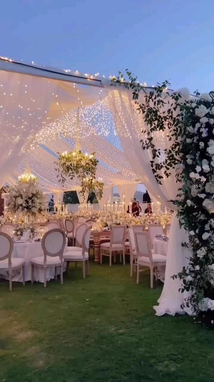 an outdoor wedding setup with white flowers and greenery