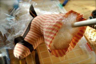 a stuffed animal hanging from a handlebar on a kitchen counter top with other items in the background