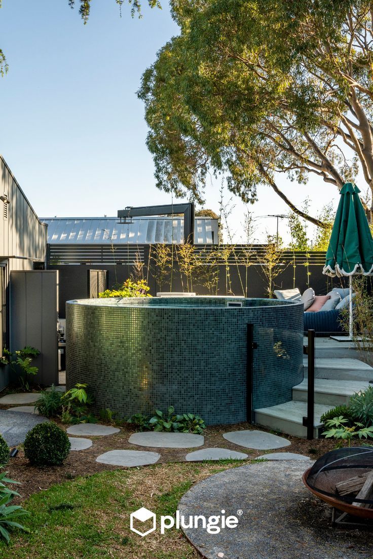 an outdoor hot tub in the middle of a garden with steps leading up to it