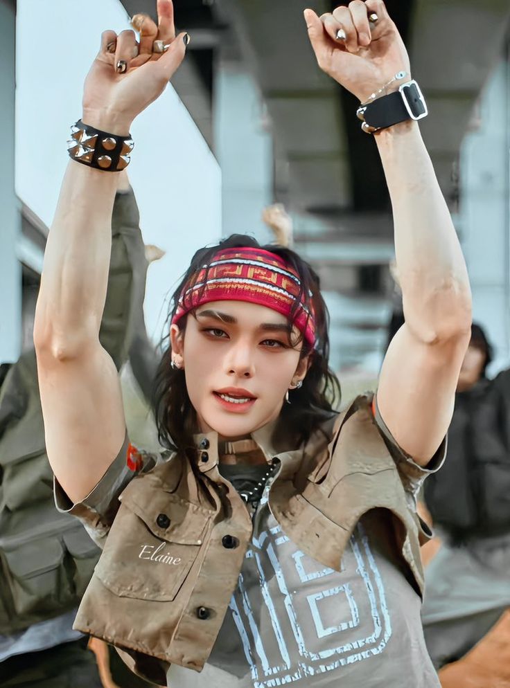 a woman with her hands in the air and wearing a bandana on top of her head