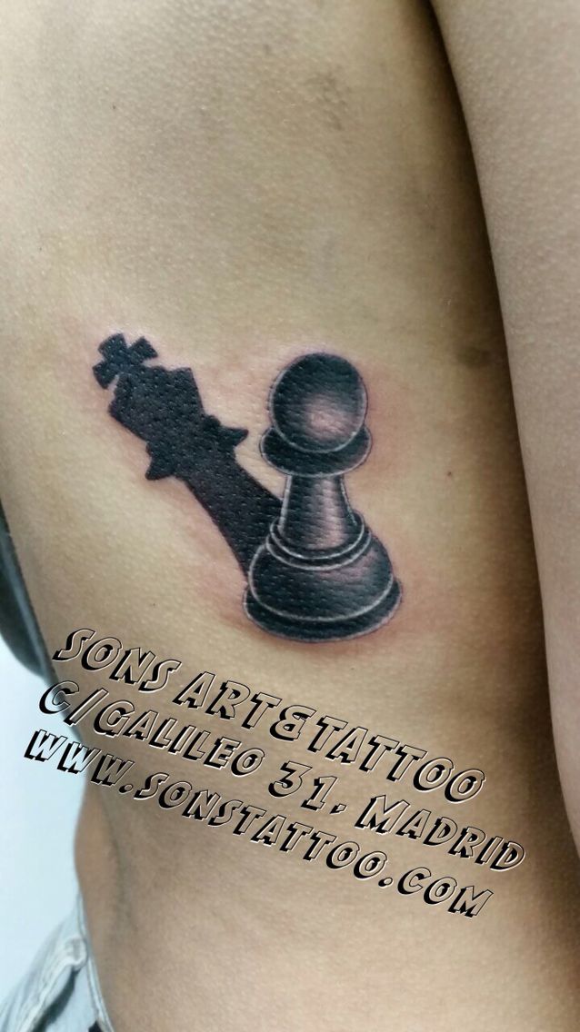 a woman's stomach with a chess piece tattoo on it