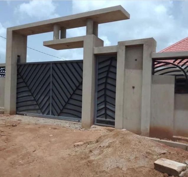 a building that is made out of concrete and has a gate in the middle of it