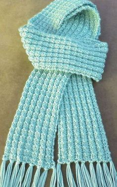 a blue knitted scarf with fringes on it