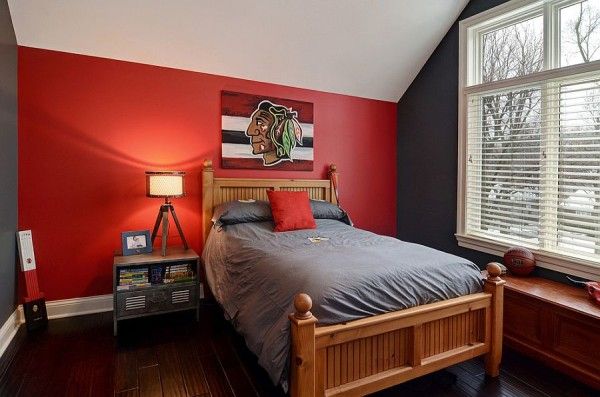 a bed room with a neatly made bed and red walls