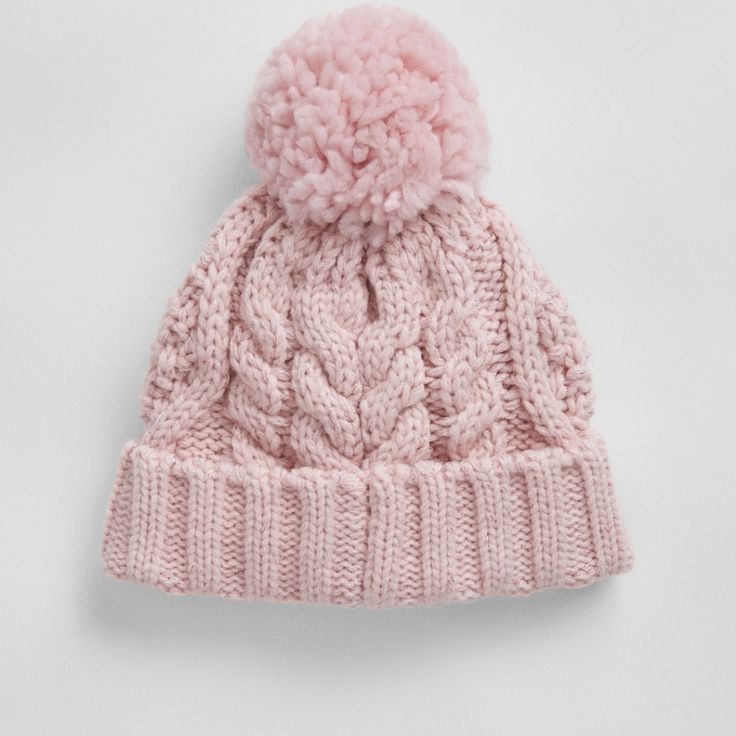 a pink knitted hat with a pom - pom