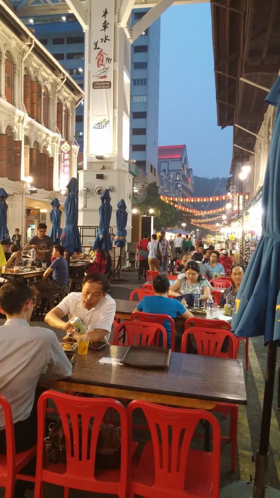 people are sitting at tables in an outdoor restaurant