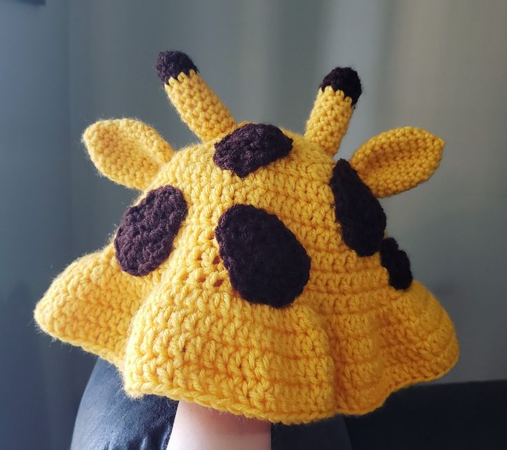 a close up of a person wearing a knitted giraffe hat