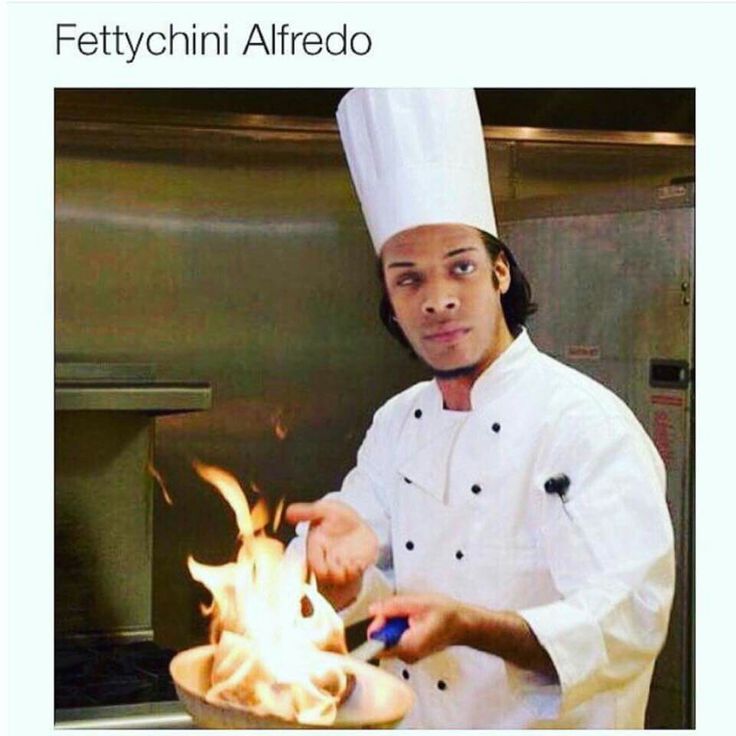 a man in a chef's hat is cooking something on a pan with flames