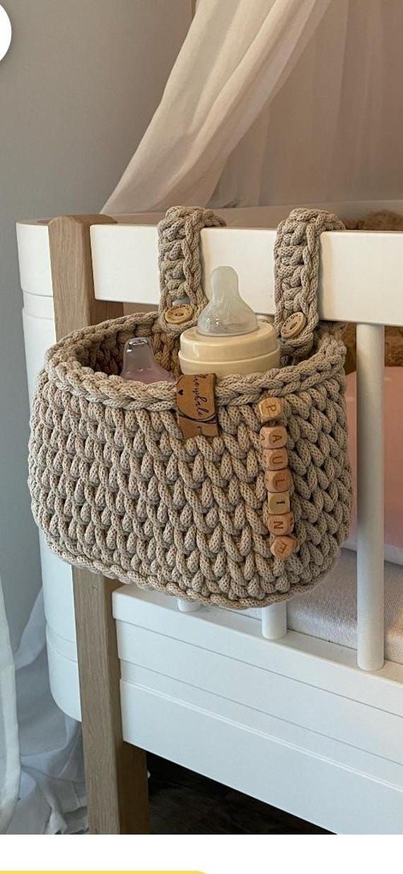 a crocheted basket on top of a white bed