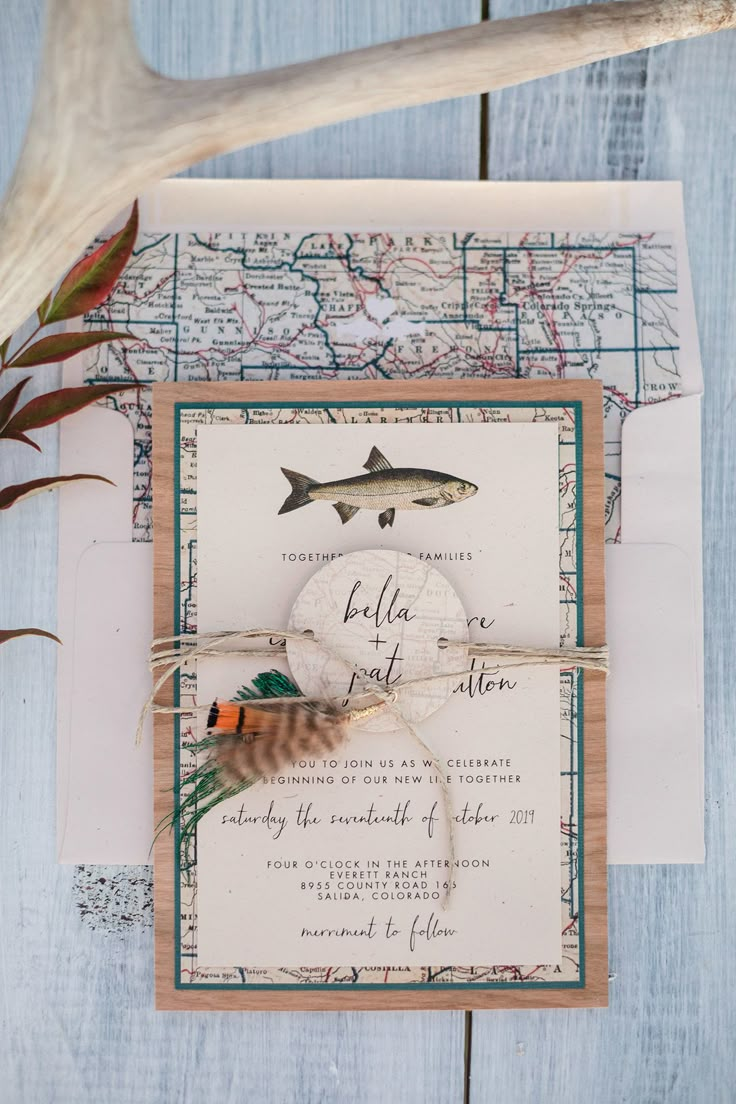 the wedding stationery is laid out on top of an old map and deer antlers