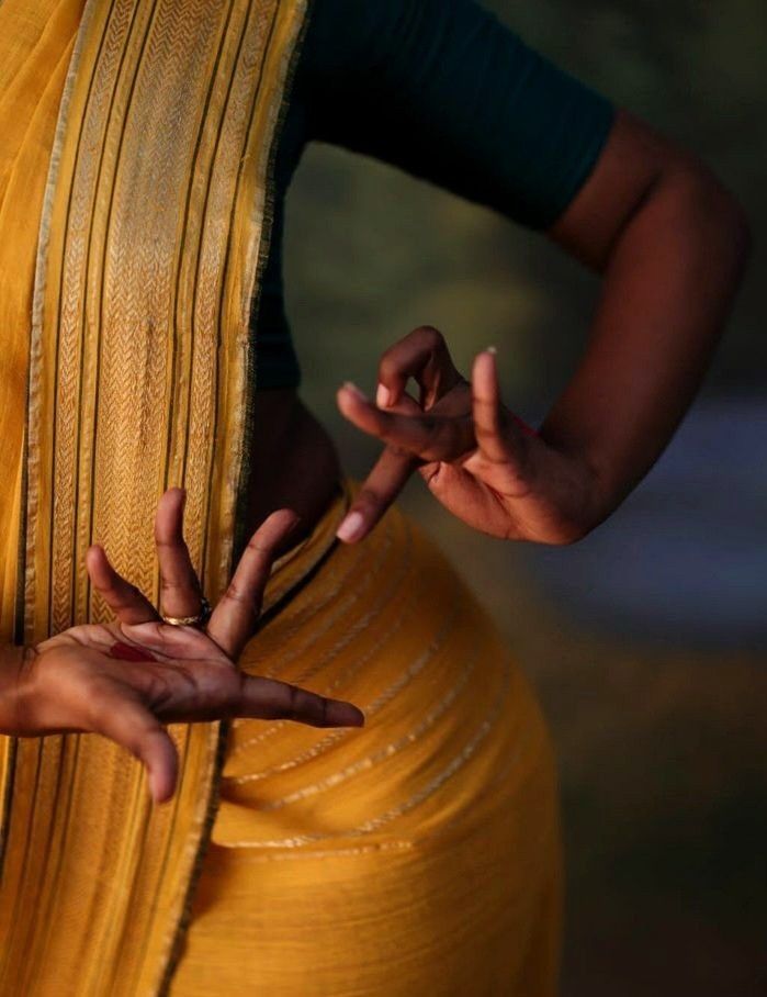 two hands reaching out to each other in front of a woman's back dress