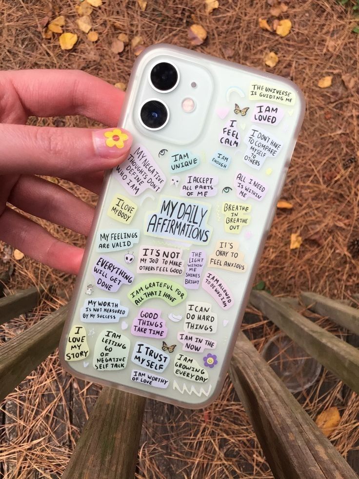 someone holding up their phone case with the words on it and stickers all over them