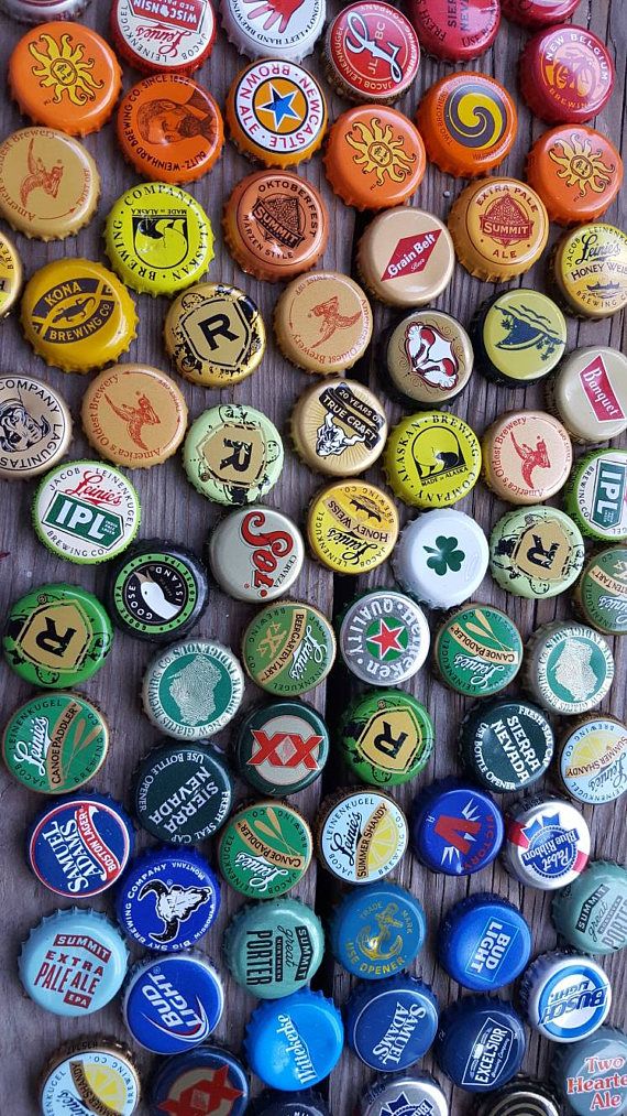 many different types of beer bottle caps on a table