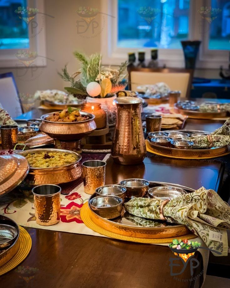 a long table with many plates and bowls on it, all set up for a meal