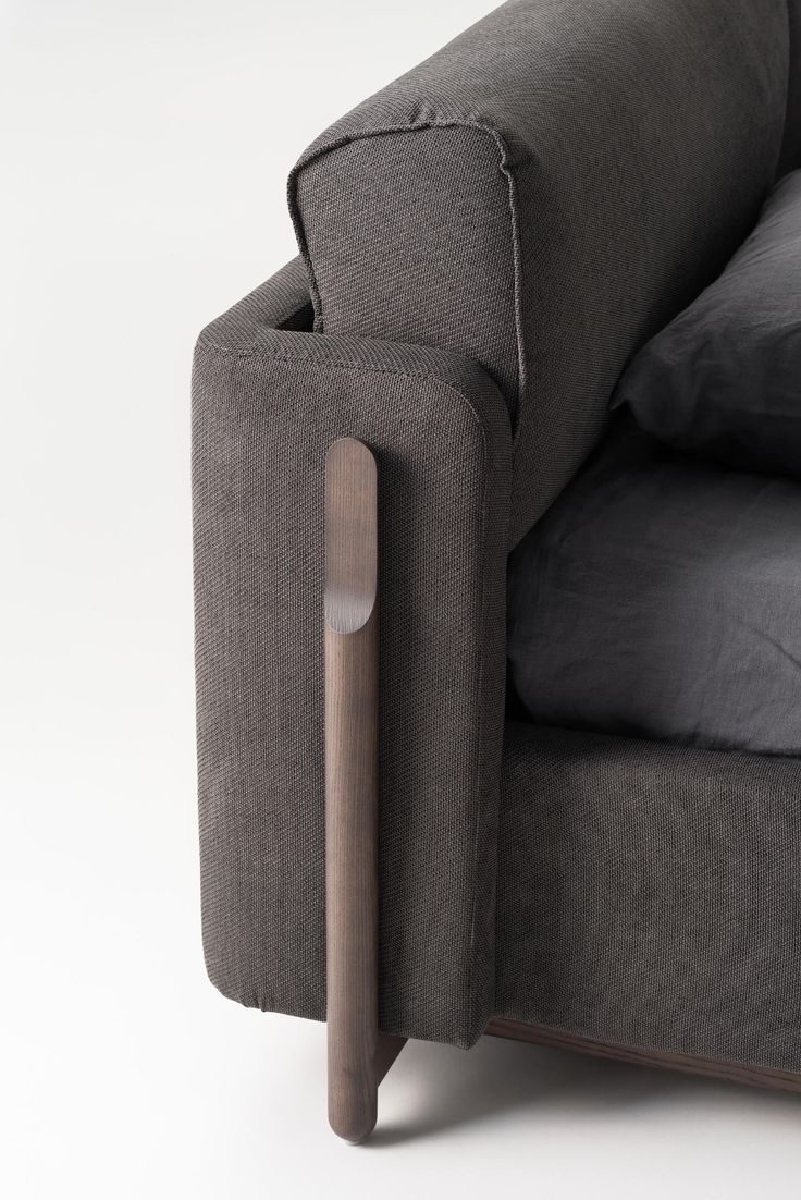 the back end of a gray couch with pillows and a pillow on it's arm