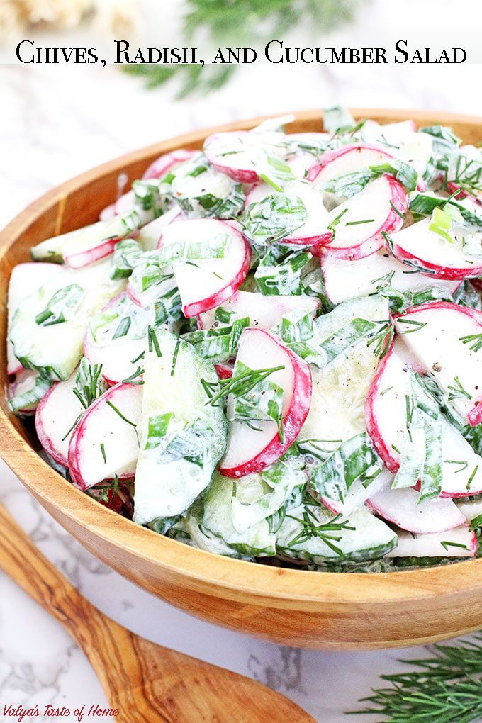 a wooden bowl filled with radishes and cheese on top of a marble counter