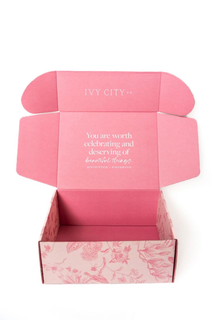 an open pink box with flowers on it and the words i'm city written in white