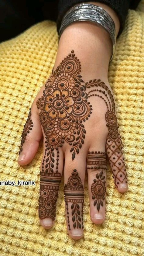 a woman's hand with henna tattoos on it