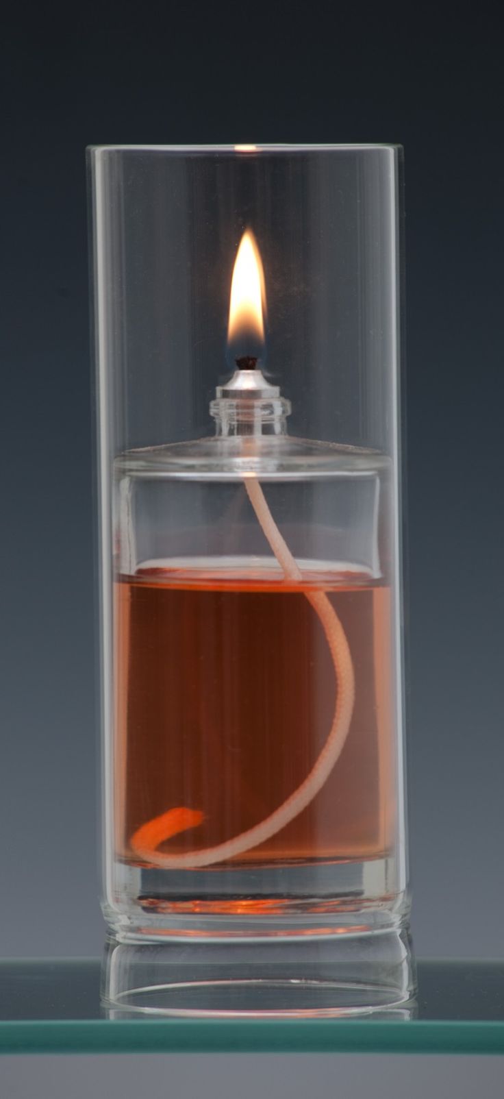 a lit candle in a glass container filled with liquid