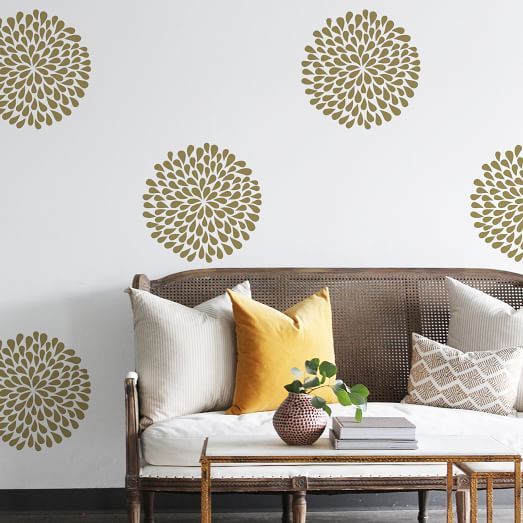 a couch with pillows on top of it next to a coffee table and wall decals