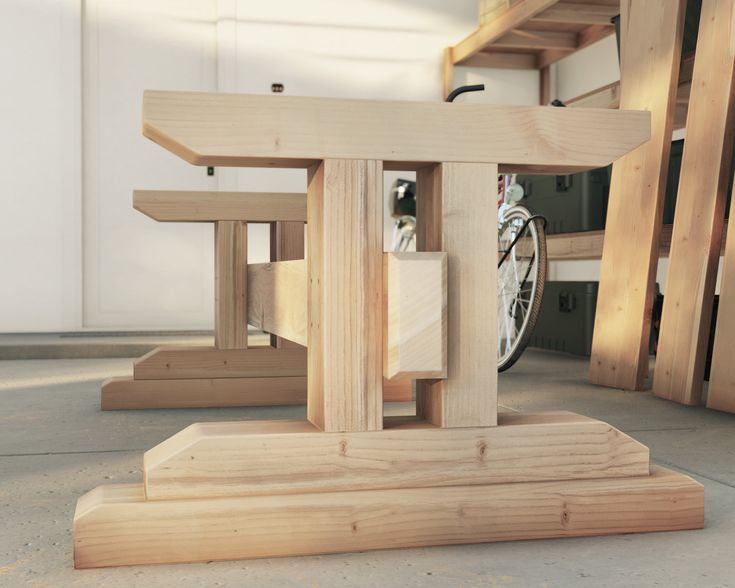 a wooden table with two benches and a bike parked in the back ground next to it