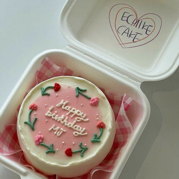 a birthday cake in a pink and white container