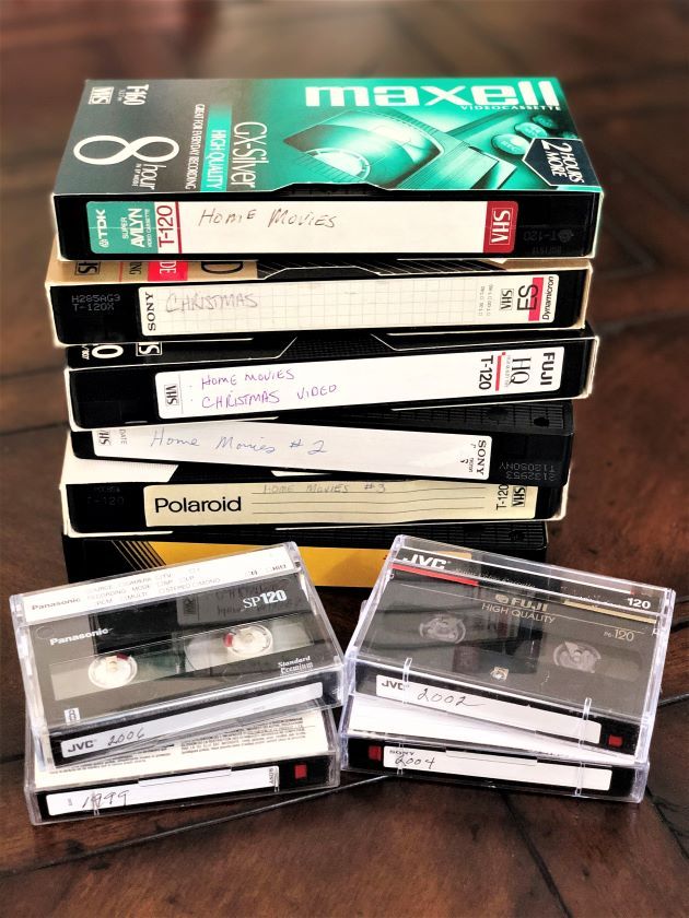 four cassettes stacked on top of each other in front of a stack of books