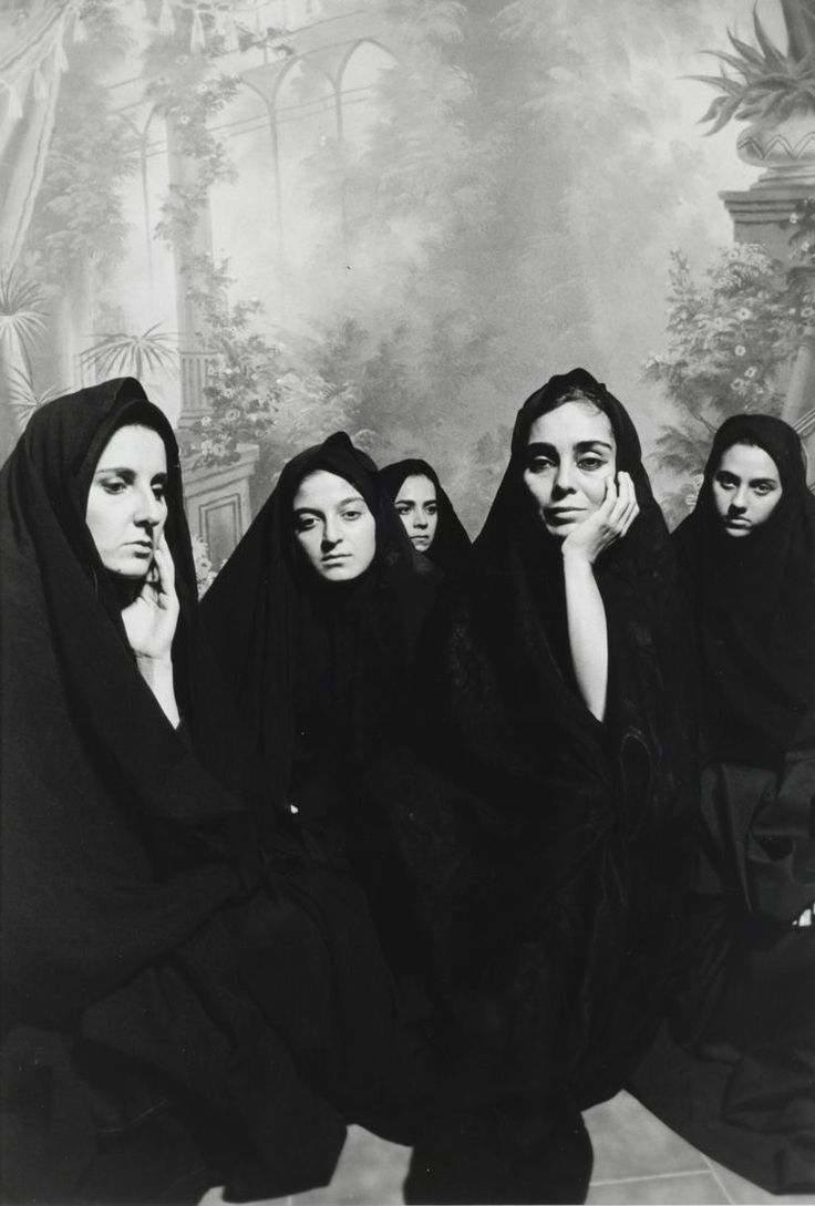 four women in black robes are posing for a photo with their hands on their chins