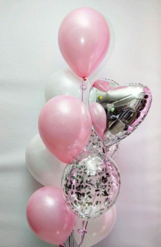 balloons and confetti are arranged in a vase