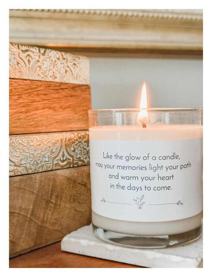 a candle with a poem on it sitting on top of a table next to a mirror