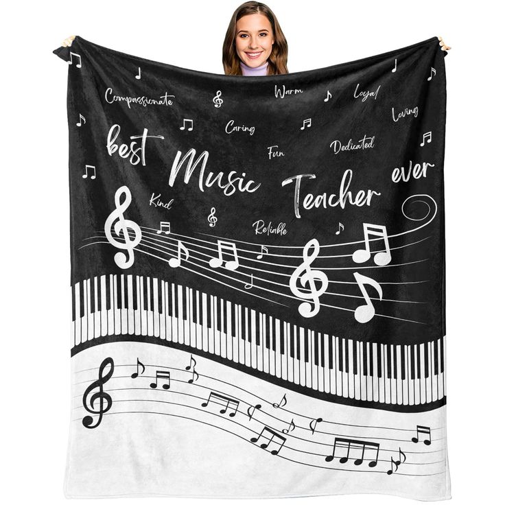 a woman holding up a black and white blanket with musical notes on it