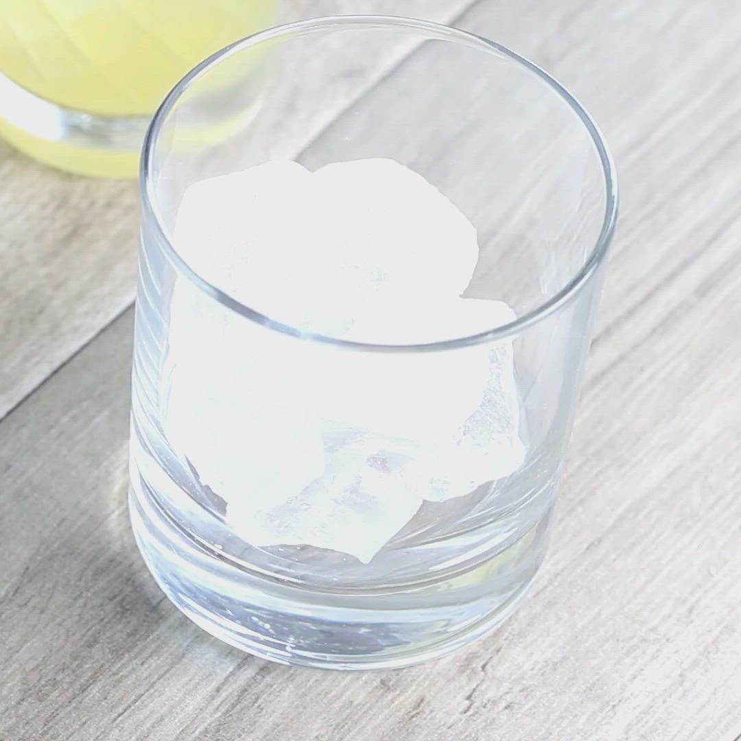 This may contain: two glasses filled with ice on top of a wooden table