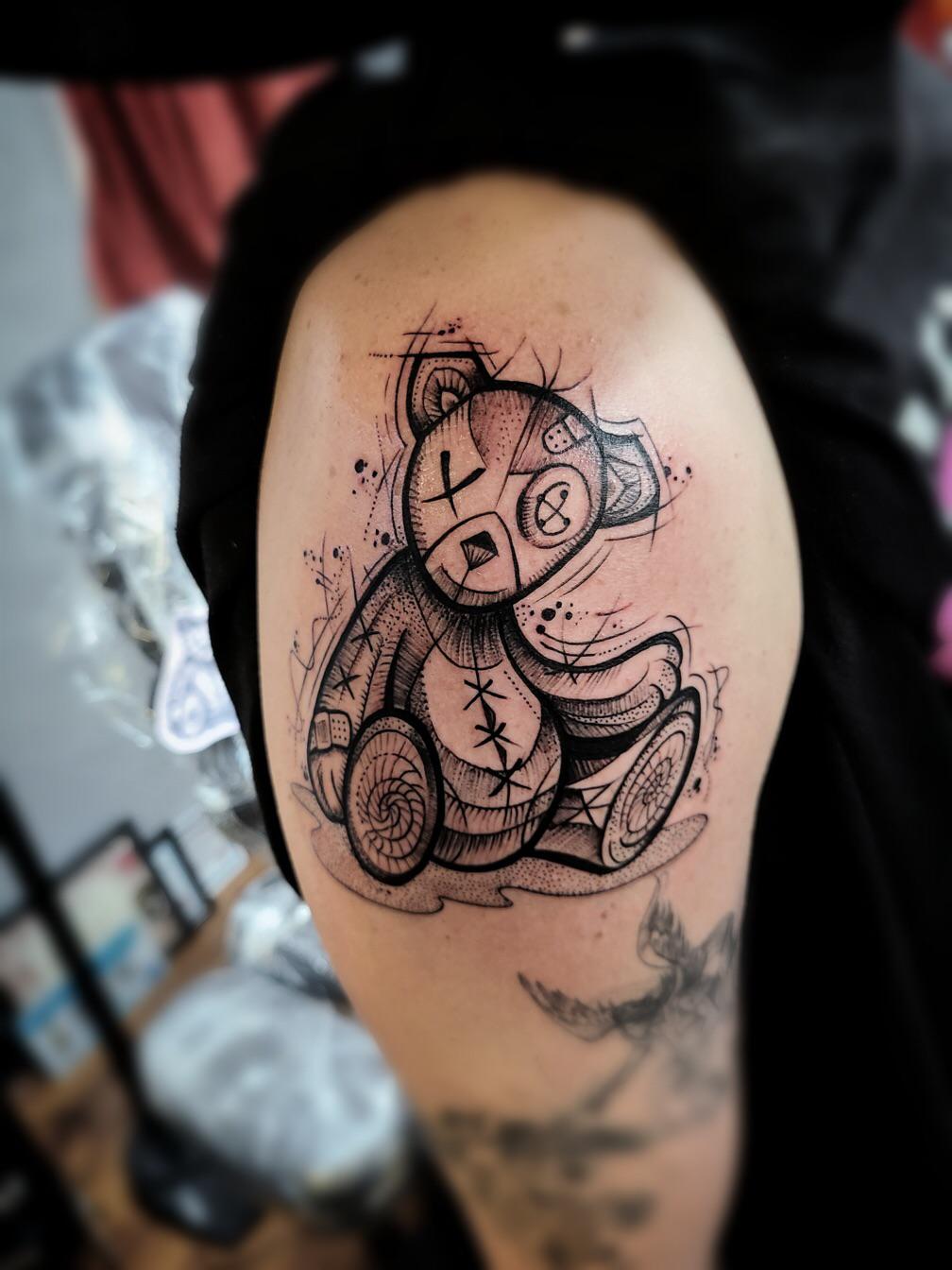 Line art teddy bear tattoo on the inner arm