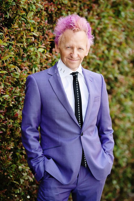 Groom in purple with pink hair.