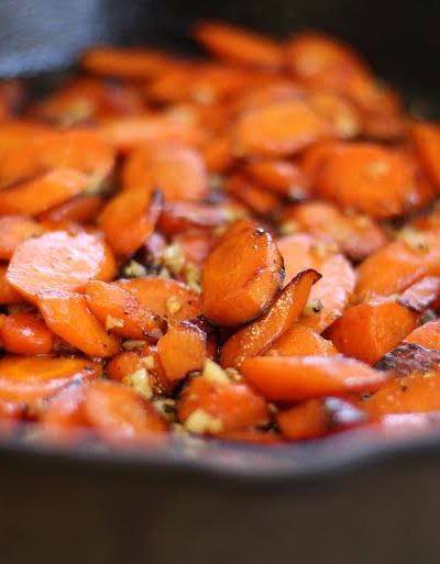 The finished cast iron carrots with garlic and honey in the cast iron pan.