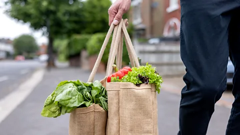 A person carries a shopping bag full of vegetables (Credit: Getty Images)