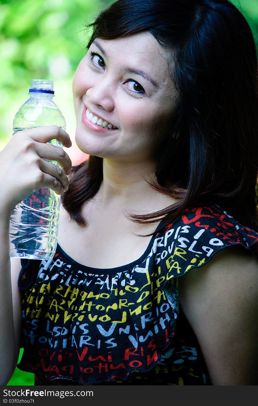 A pretty girl is drinking mineral water