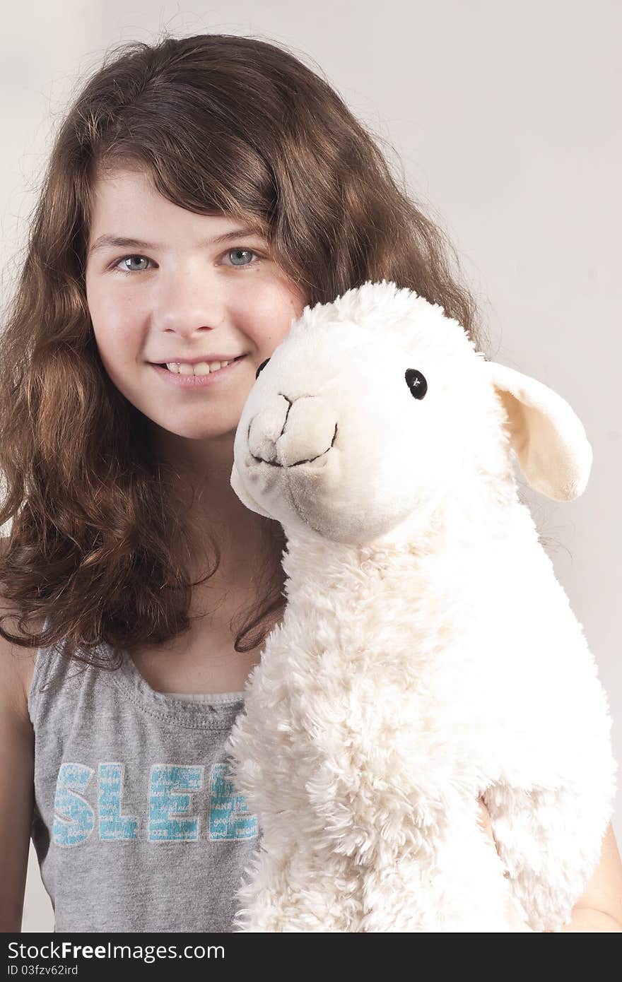 Young happy girl with  stuffed animal sheep