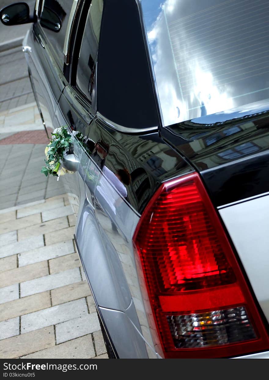 Luxury silver and black wedding limousine with bouquet on the street. Luxury silver and black wedding limousine with bouquet on the street.