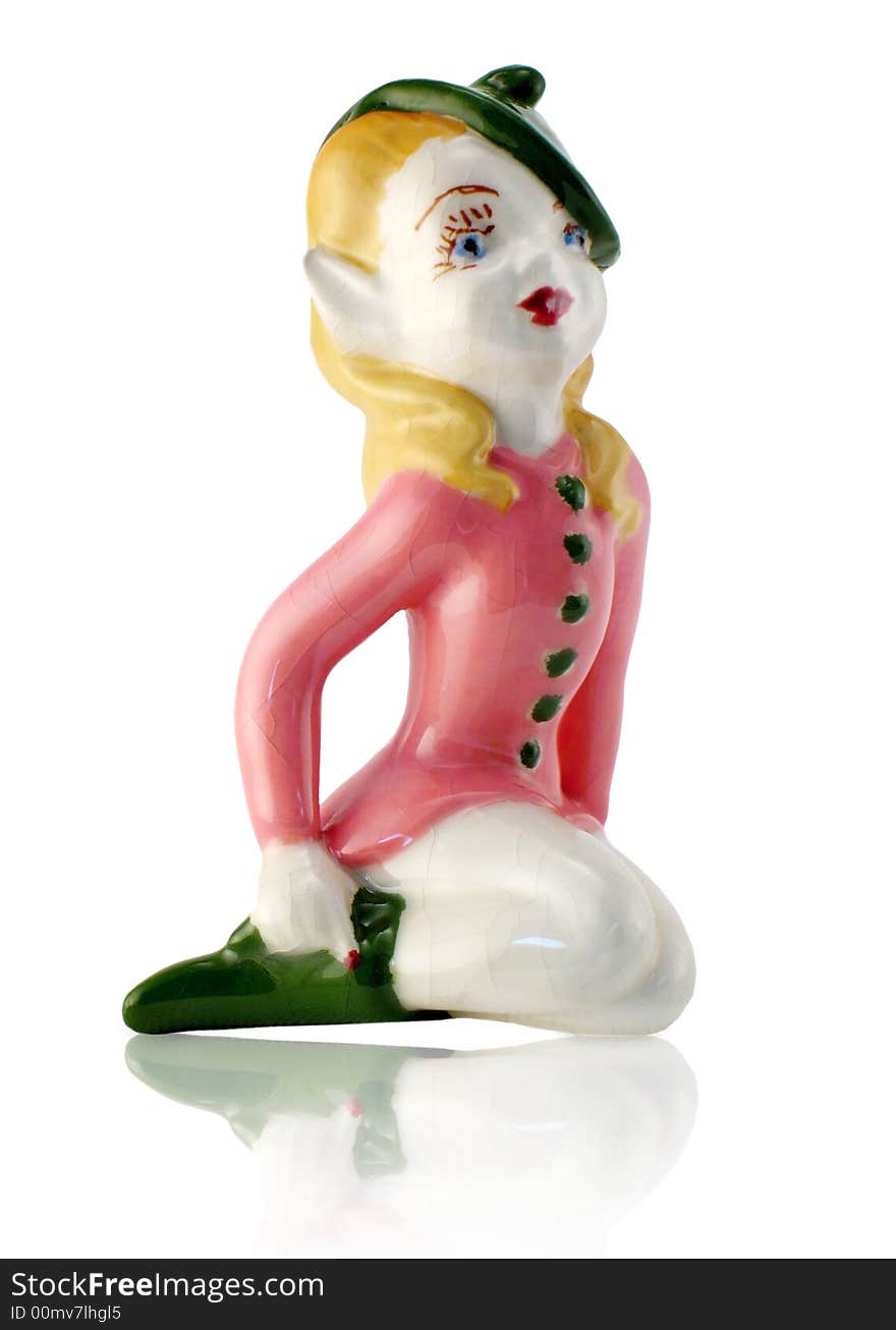 Saucy Elf Girl sitting; vintage porcelain figurine; isolated with reflection. Saucy Elf Girl sitting; vintage porcelain figurine; isolated with reflection