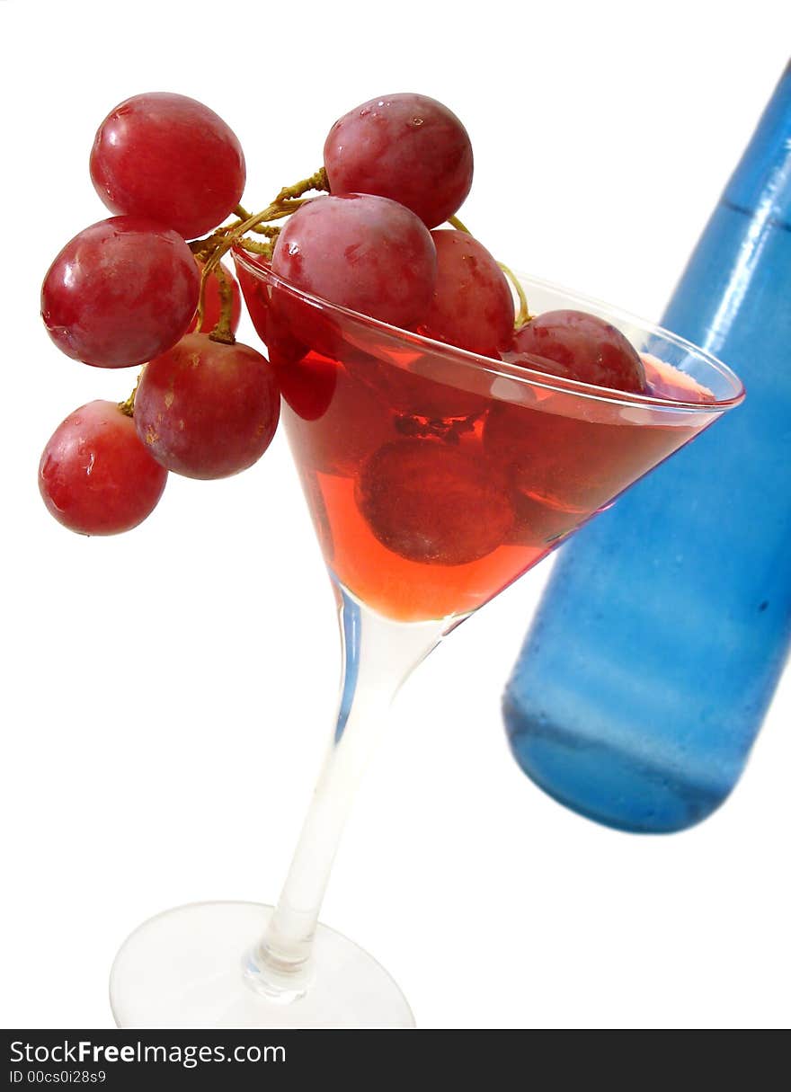 Red wine with grapes and blue bottle over white background