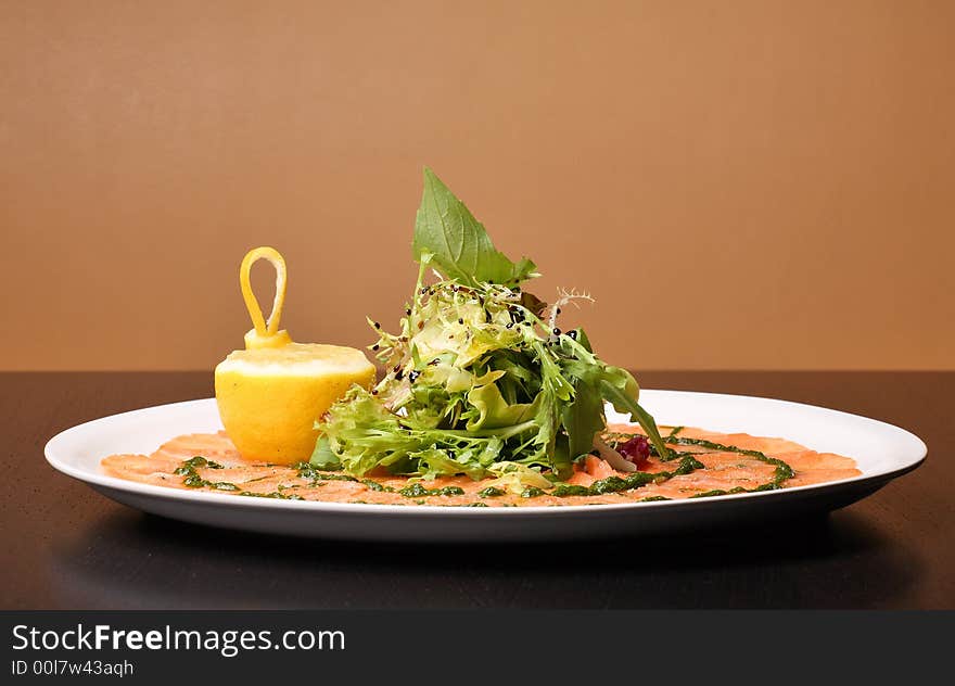 Italian dish: carpaccio with salmon and lemon (lime) and fresh pesto