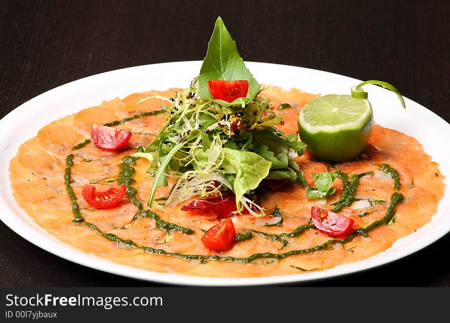 Italian dish: carpaccio with salmon and lemon (lime) and fresh pesto