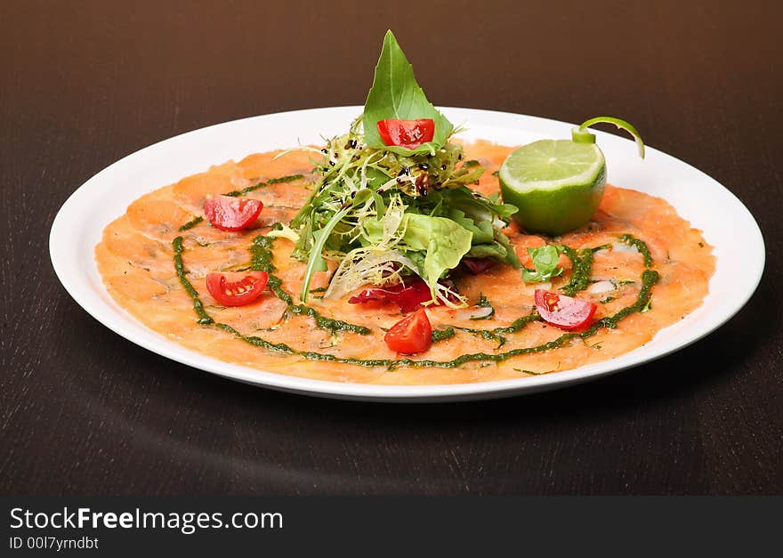 Italian dish: carpaccio with salmon and lemon (lime) and fresh pesto