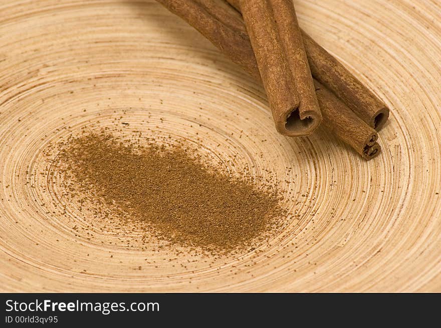 Powdered cinnamon with pieces of cinnamon on the bamboo platter