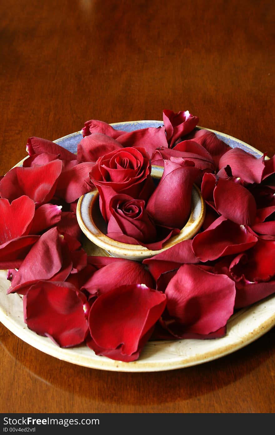 Rose buds and petals on ceramic platter. Rose buds and petals on ceramic platter